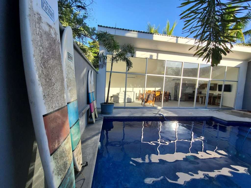 The private pool with surfboards and the glass common area at Hotel Zocalo